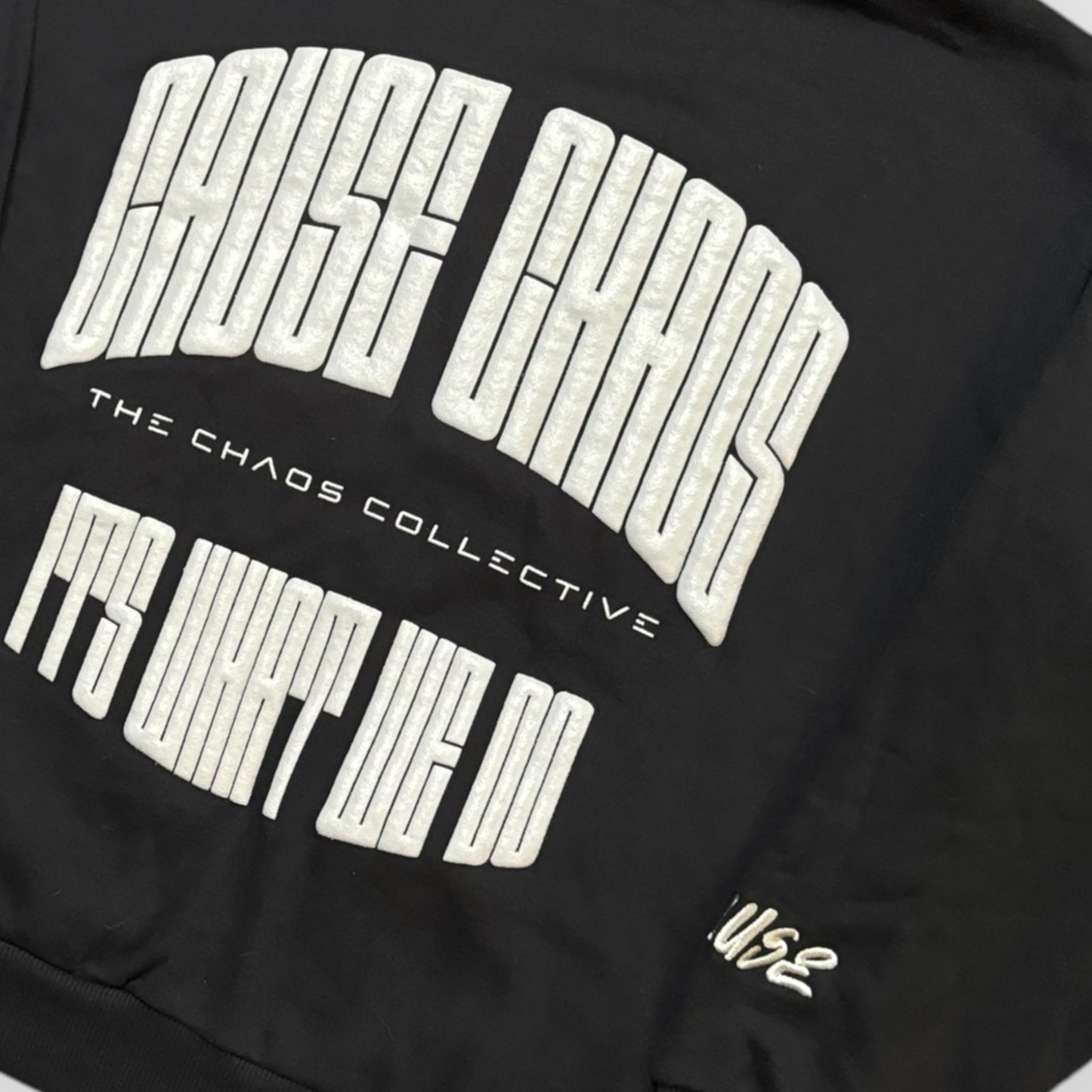 IT’S WHAT WE DO! BLACK PUFF HOODIE - Front View - Flat Lay Logo